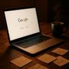 Closeup of a sleek laptop resting on a rustic wooden desk its screen glowing with a vibrant Google search window