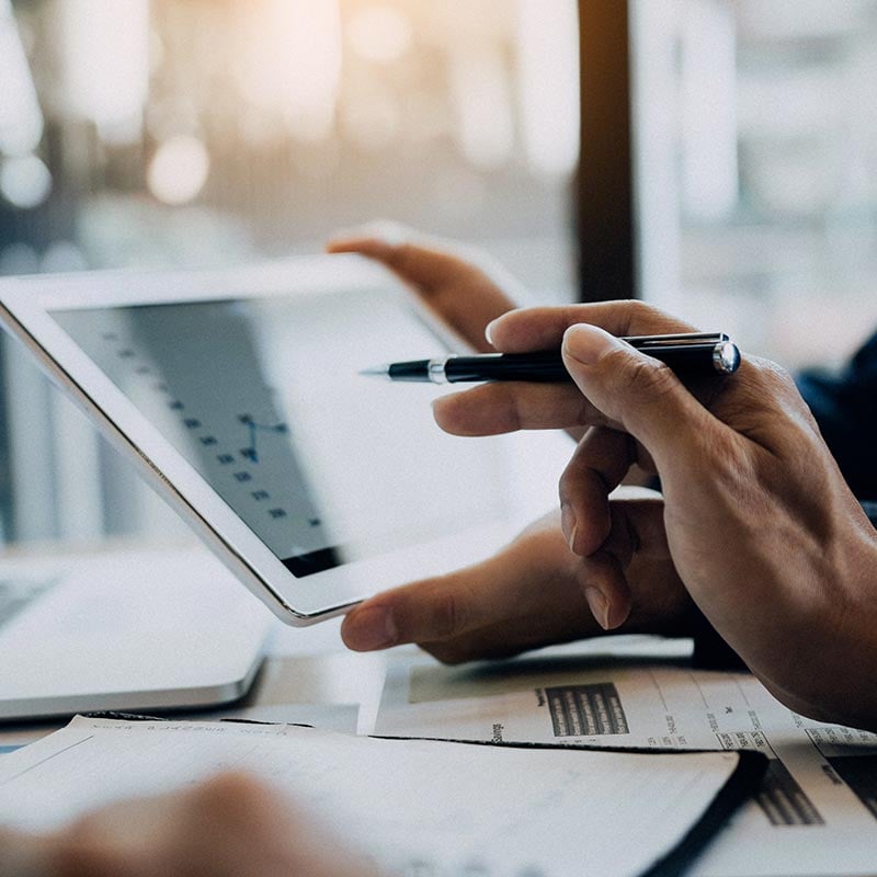 Coworkers using a tablet to analyze graph of company's financial budget report