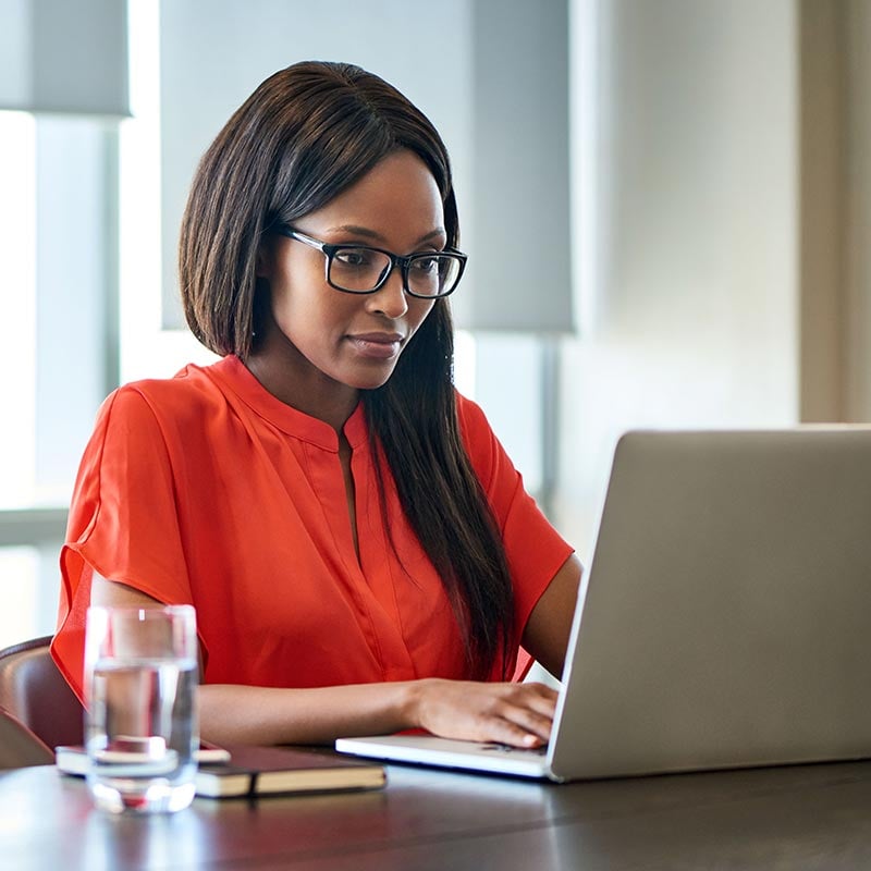 Focused young businesswoman working on a laptop in an office