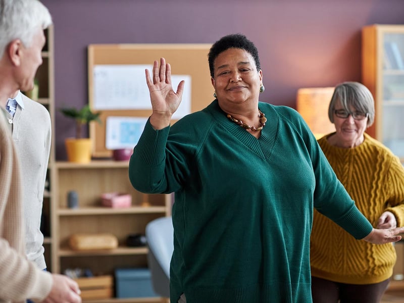 Waist-up portrait of a senior woman dancing in a senior living community 